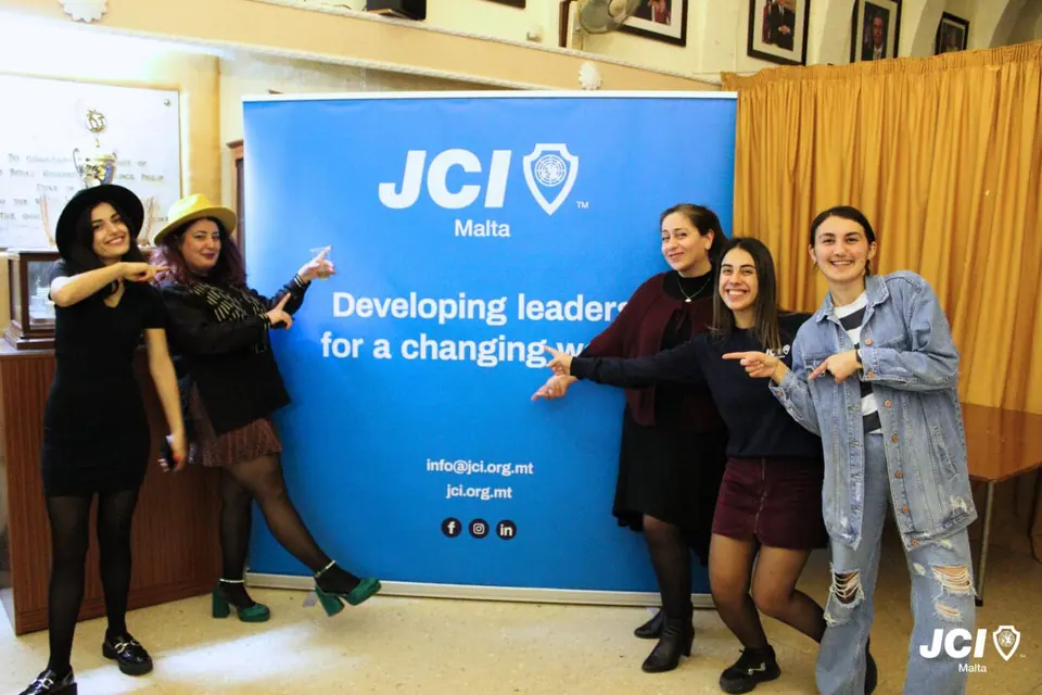 JCI Malta members in front of a JCI banner